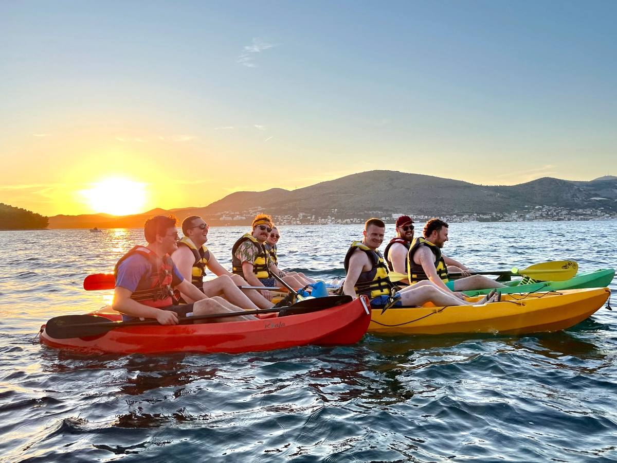 Group kayaking at sunset